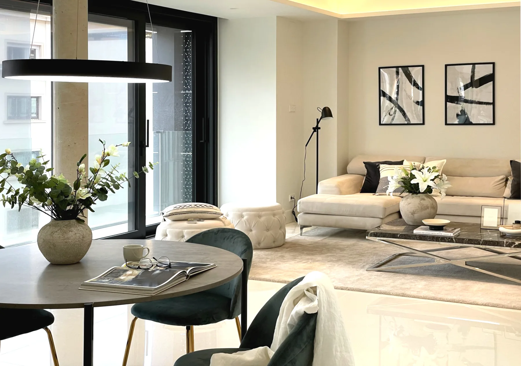 Salón comedor con mesa de piedra, sillas de terciopelo verde y lámpara circular negra